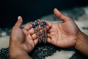 Equalitude, unique bracelets shown in open hands. Each bead signifies a skintone of someone from around the world